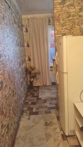 a kitchen with a refrigerator and a tile floor at Квартира по суточно in Taraz