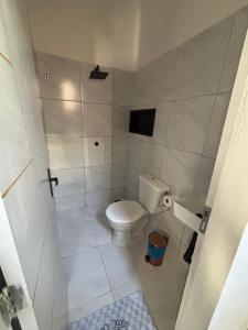 a small bathroom with a toilet and a shower at Studio completo, perto da praia! in São Luís
