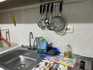a kitchen sink with utensils hanging above it at Tayra Living Suites in Mocoa +39 photos