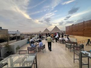 a group of people sitting on a roof with pyramids at Pyramids Motel in Cairo