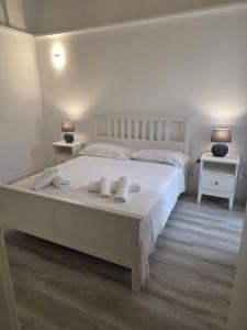 a bedroom with a large white bed with towels on it at Lupiae retreat in Lecce