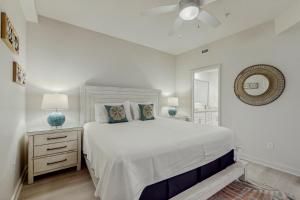 Un dormitorio blanco con una cama y un ventilador de techo. en Sea Glass 203- No Worries, en Gulf Shores 15 fotos más