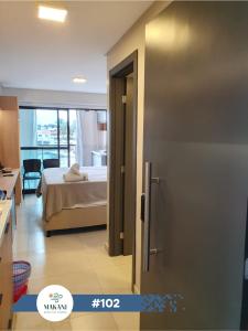 um quarto com uma cama e uma porta para um quarto em Makani Beach Flat Campas #102 - Frente Norte Alto Padrão em Tamandaré