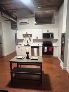 a kitchen with white cabinets and a table in a room at The hancock loft in Philadelphia +6 photos