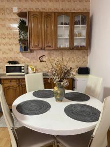 a kitchen with a table with a vase of flowers on it at Apartman Kulenović in Kulen Vakuf
