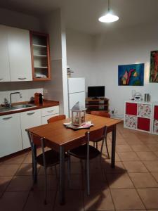 a kitchen with a wooden table with chairs and a sink at La DUNA in Torvaianica +5 photos