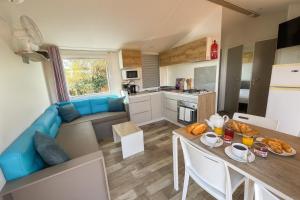 a kitchen and a living room with a table and chairs at Le Cocon De L'Océan in Saint-Hilaire-de-Riez