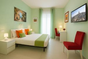 Un dormitorio con una cama grande y una silla roja. en Green House, en Matera