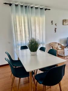 un comedor con una mesa blanca y sillas azules en Ocean Gardens, en Caniço 7 fotos más
