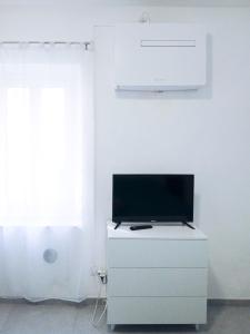 a tv sitting on top of a white dresser at Sanremo Apartments - Il Vicoletto in Sanremo