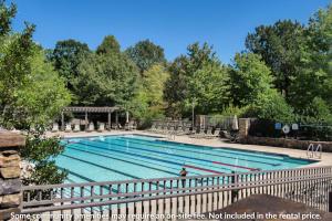 a large swimming pool with a fence around it at Heaven and Earth - Luxury Accomodations, Breathtaking Mountain Views, Game Rooms + More! in Jasper