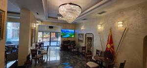 a restaurant with tables and chairs and a chandelier at ANGELS View in Skopje