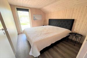 a bedroom with a bed in a room with a window at M184-Vaeggerlose-Kaninstien-41 in Bøtø By