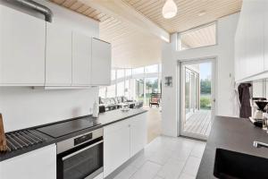 a kitchen with white cabinets and a view of a patio at M14010-Vaeggerlose-Savavej-29 in Marielyst +12 photos