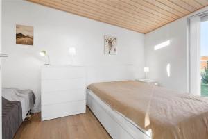 a white bedroom with a bed and a window at M14010-Vaeggerlose-Savavej-29 in Marielyst