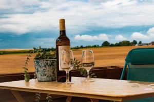 a bottle of wine sitting on a table with two glasses at Chambre Henriette in Incourt