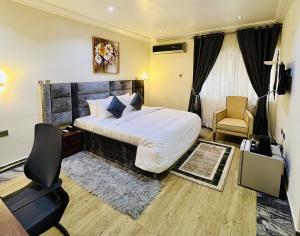 a hotel room with a bed and a chair at Abuja Enclave Retreat in Abuja