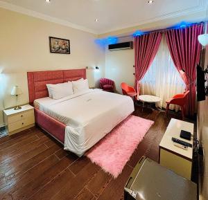 a bedroom with a large bed and a pink rug at Abuja Enclave Retreat in Abuja
