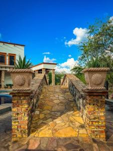 a stone walkway leading to a house with a pool at Álamos Bonito Resort in Álamos