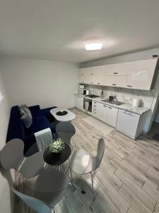 un soggiorno con divano blu, tavolo e sedie di Apartament Guziczek a Nowy Targ