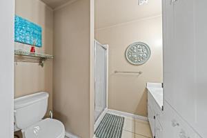a white bathroom with a shower and a toilet at Ava and Weston Combo House in Fredericksburg +14 photos