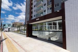 a large building with glass windows on a street at Belém COP30 Apartment in Belém