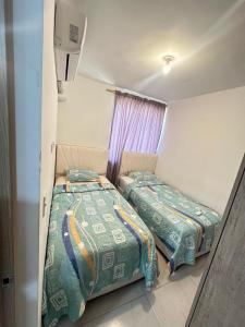 巴兰基亚MY lOVE BARRANQUILLA 1的有两张床和一扇窗户的卧室