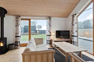 a living room with a couch and a table and a fireplace at S11-Stubbekobing-Kongsnaesparken-94 in Stubbekøbing