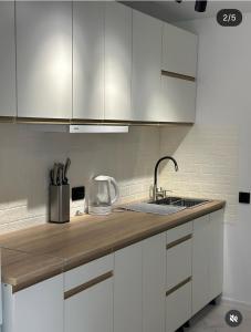 a kitchen with white cabinets and a sink at Pink House Karpaty in Krivorovnya +18 photos