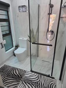 a bathroom with a shower with a zebra print rug at Indulge luxury overnight accommodation in Middelburg +8 photos
