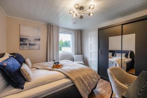 Un dormitorio con una cama grande y un espejo. en Riverside Luxury Retreat By BookLapland, en Rovaniemi