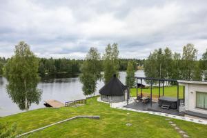 une maison avec un kiosque à côté d'un lac dans l'établissement Riverside Luxury Retreat By BookLapland, à Rovaniemi