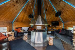 una sala de estar con sofás y TV en una cabaña en Riverside Luxury Retreat By BookLapland, en Rovaniemi