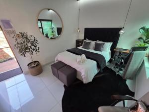 a bedroom with a large bed and a mirror at Indulge luxury overnight accommodation in Middelburg