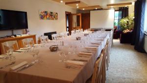 a long table with glasses and napkins on it at Hotel Les Sapins in Le M&eacute;nil