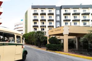 a bus driving down a street in front of a hotel at Topaz Hotel in St Paul's Bay