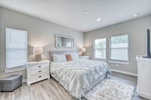 a bedroom with a bed and a mirror and windows at The Ricardo in Fredericksburg