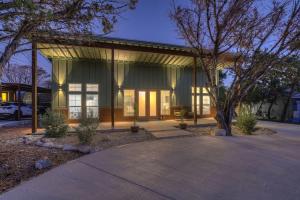 a home with a large glass building with a tree at Serene Guadalupe River Getaway-River Access! in Cranes Mill