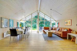 un soggiorno con un divano, un tavolo e delle sedie di M324-Vaeggerlose-Baeverstien-10 a Bøtø By