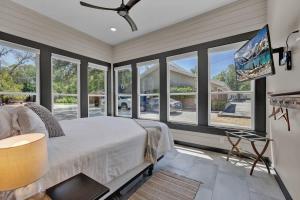 een slaapkamer met een bed en grote ramen bij Historic Gem near Schlitterbahn in New Braunfels