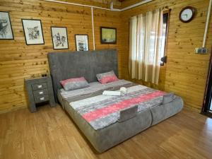 a bedroom with a large bed and a clock on the wall at Sojenica Asije in Ulcinj