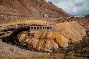 a painting of a building on a rocky mountain at Cabaña Regivan en Uspallata in Uspallata