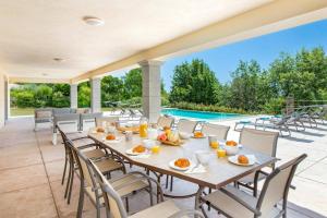 a dining room with a table and chairs and a pool at Villa Diamant by Villa Plus in Saint-Cézaire-sur-Siagne