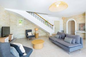 a living room with two couches and a staircase at Villa Diamant by Villa Plus in Saint-Cézaire-sur-Siagne