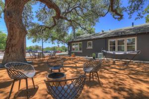 een groep stoelen en een boom voor een huis bij Historic Gem near Schlitterbahn in New Braunfels