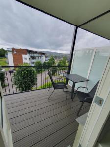 a balcony with a table and two chairs at Komfort in Lier