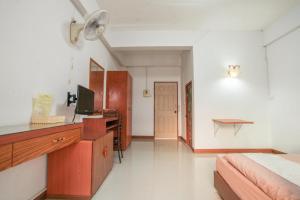 a bedroom with a bed and a desk with a computer at โรงแรมบ้านสวน ฟ้าใส in Chanthaburi