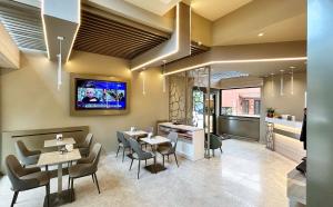 a restaurant with tables and chairs and a tv on the wall at Hotel Real in Cinisello Balsamo