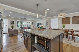 a kitchen and living room with a large island at Luxury Mid Century Charmer Near Historic Main St in Fredericksburg +18 photos
