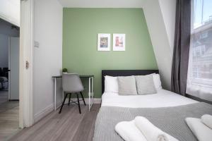 a small bedroom with a bed and a chair at Strand Central Apartments 4th Floor in London
